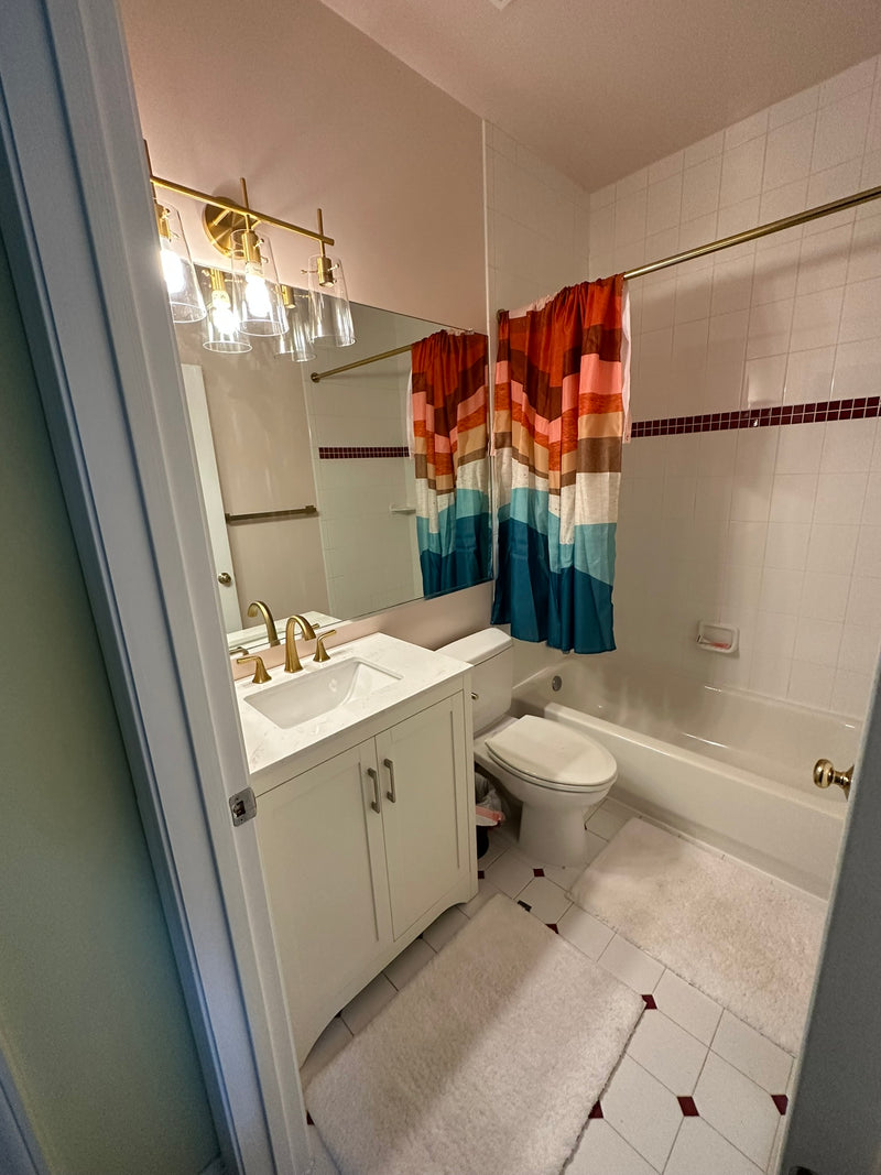 Updated bathroom with a new vanity, toilet, fixtures, mirror, and paint in Glenelg Maryland